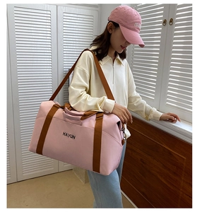 Detail of pink large-capacity fitness travel bag with brown straps and HAYUN lettering