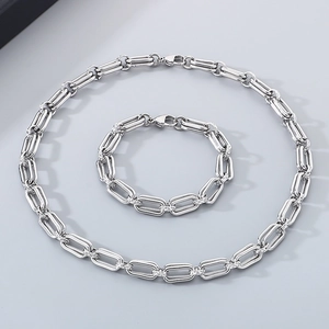 Flat lay of a silver paperclip chain necklace and bracelet set in stainless steel