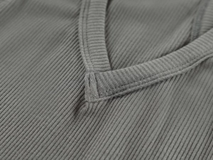 Close-up of gray ribbed fabric texture and V-neck stitching on high-stretch sports vest