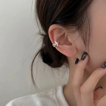 Close-up of silver ear cuff with sparkling zircon petals on a model's ear