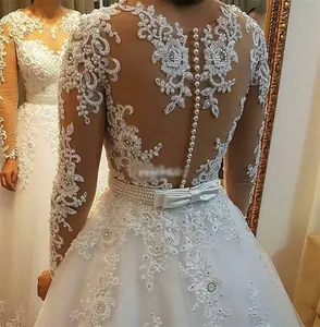 Detail of bridal dress featuring floral lace embroidery, pearl beads and back button closure