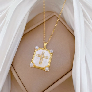 Elegant gold titanium necklace with pearl and diamond cross pendant on silk