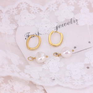 Close-up of elegant gold pearl earrings with pave diamonds on baroque pearl drops