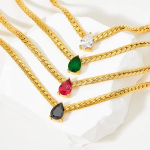 Gold snake chain necklace with pear-cut gemstones in emerald, ruby, black, and clear