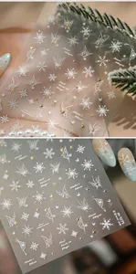 Macro detail of M-1275 nail stickers featuring white snowflakes and gold butterfly patterns