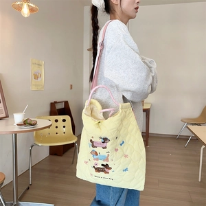 Close-up of yellow quilted tote bag with cute dog embroidery and Have a nice day text