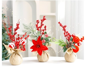 Close-up of mini Christmas pine trees with red berries and burlap base decoration