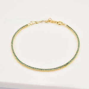Detail of gold tennis bracelet with light blue zircons and adjustable lobster clasp