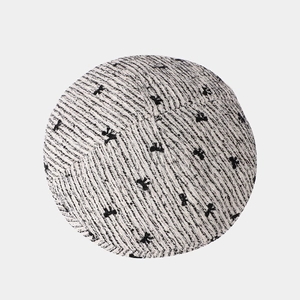 Detailed top view of black and white tweed beret with elegant black bow decoration