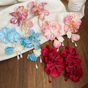 Detailed flat lay of floral fabric earrings with pearls in burgundy, blue and pink hues