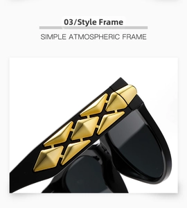 Detail of black eyewear temples with three rows of gold pyramid studs on a white background