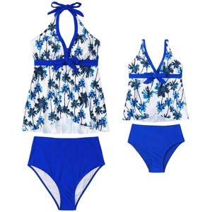Détail d'ensemble de maillots de bain mère-fille à imprimé palmier et nœud bleu