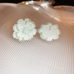 Detail of light green floral earrings with delicate layers and silver needle backing