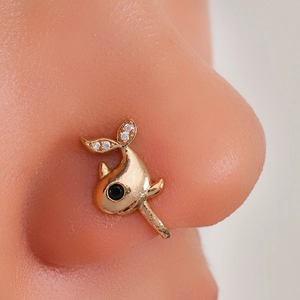 Macro shot of gold whale nose cuff with black and white cubic zirconia on silicone model