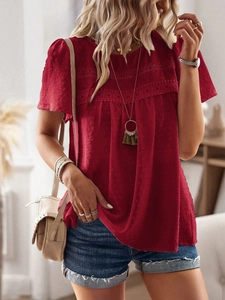 Close-up detail of red short-sleeve top featuring hollow lace and polka dot texture