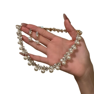 Elegantes vergoldetes Schmuckset mit diamantbesetzten Perlen an Halskette und Ohrringen