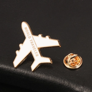 Macro shot of 3D airplane pin with World Traveler engraving on black leather background