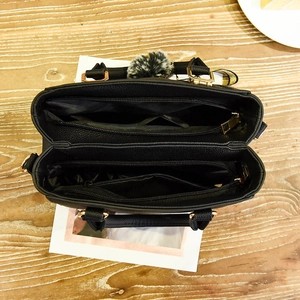 Black minimalist PU leather handbag with multi-compartment interior and pom-pom charm