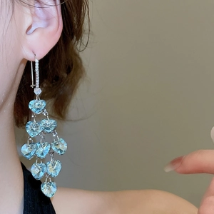 Detail of light blue heart-shaped crystal tassel earrings with sparkling zircon inlay