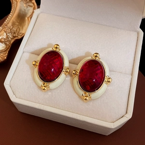 Vue macro de boucles d'oreilles vintage ovales avec pierre rouge et émail crème