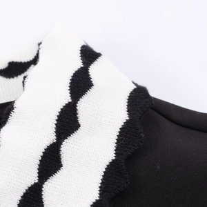 Détail de la texture tricotée à motif de vagues noir et blanc sur un polo femme