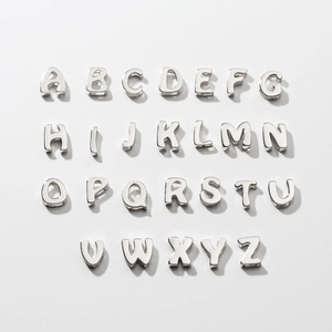 Detailed flat lay of 26 English letter pendants in polished S925 sterling silver