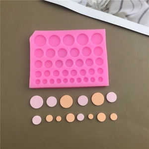 Pink silicone baking mold with various sizes of round cavities for chocolate or fondant