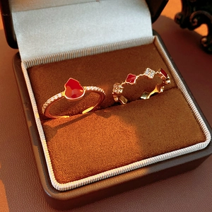 Detailed view of 18k gold plated gourd and clover rings in a brown velvet jewelry box