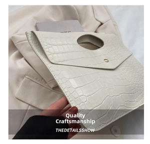 Close-up of off-white tote with crocodile texture and gold button detail