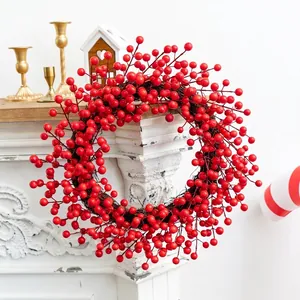 Christmas red berry wreath decoration hanging on a white fireplace with a festive bow