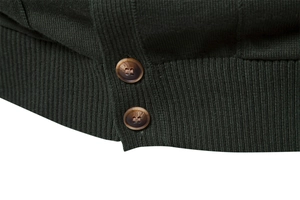 Macro detail of dark green knit sweater with brown buttons and ribbed hem texture