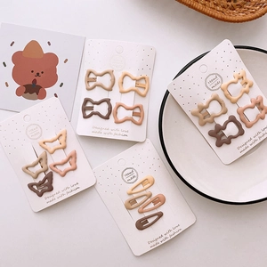 Matte earth-tone hair clip set with butterfly and heart shapes on display cards