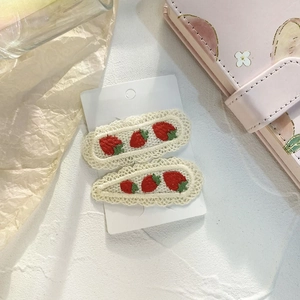 Detail of sweet strawberry embroidered hair clips set with white lace crochet edges