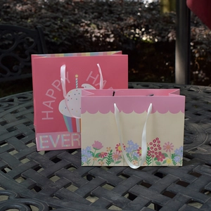 Floral printed paper gift bags with white ribbon handles and scalloped edges for Mother's Day
