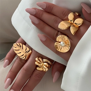 Set of four gold vintage style rings featuring monstera leaf and butterfly designs
