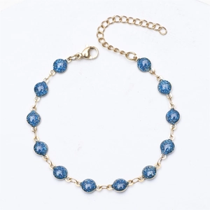 Detail of 18K gold plated chain with blue glitter beads and lobster clasp closure