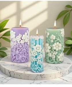 Detailed close-up of 3D floral embossed pillar candles in purple, blue and green colors
