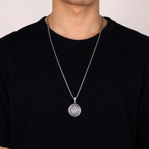 Close-up of a vintage hammered texture stainless steel round pendant necklace on a model