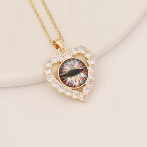 Macro shot of gold heart pendant with cubic zirconia and a colorful evil eye design