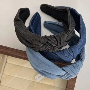 Three shades of denim knot headbands displayed on a wooden tray for a vintage style look