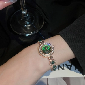 Detail of vintage flower-shaped watch with green dial and rose gold gemstone bracelet