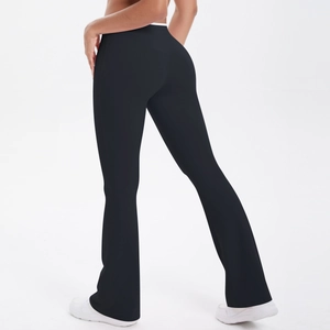 Detail showing the flared hem and sculpting fabric of the high-waisted black yoga pants