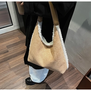 Close-up of brown suede tote bag with white lamb wool trim and leather shoulder strap