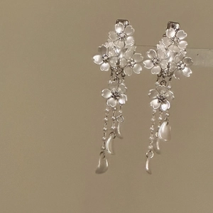 Macro detail showing elegant white flower hair clips with cascading pearl tassel charms