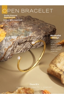 Close-up of minimalist open gold bracelet with double cubic zirconia on natural rock