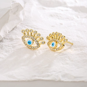 Elegant gold Evil Eye stud earrings with blue enamel and sparkling crystals on stone