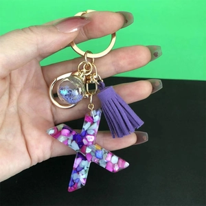 Macro detail of starfish resin keychain with purple tassel and colorful stones
