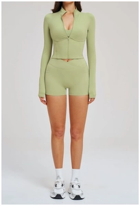Detail of light green sports set featuring a zipper crop top and cross waist shorts