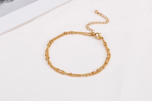 Close-up of golden double-layer beaded chain bracelet with lobster clasp and extender