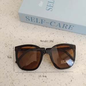 Close-up of kids black sunglasses with brown lenses and UV400 protection detail